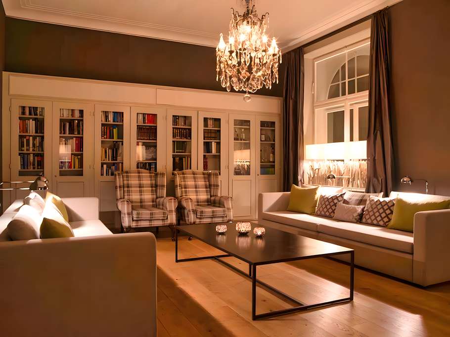 Gemütliche Bibliothek mit hohen Bücherregalen, Holzmöbeln und warmem Licht in einem ruhigen Innenraum.